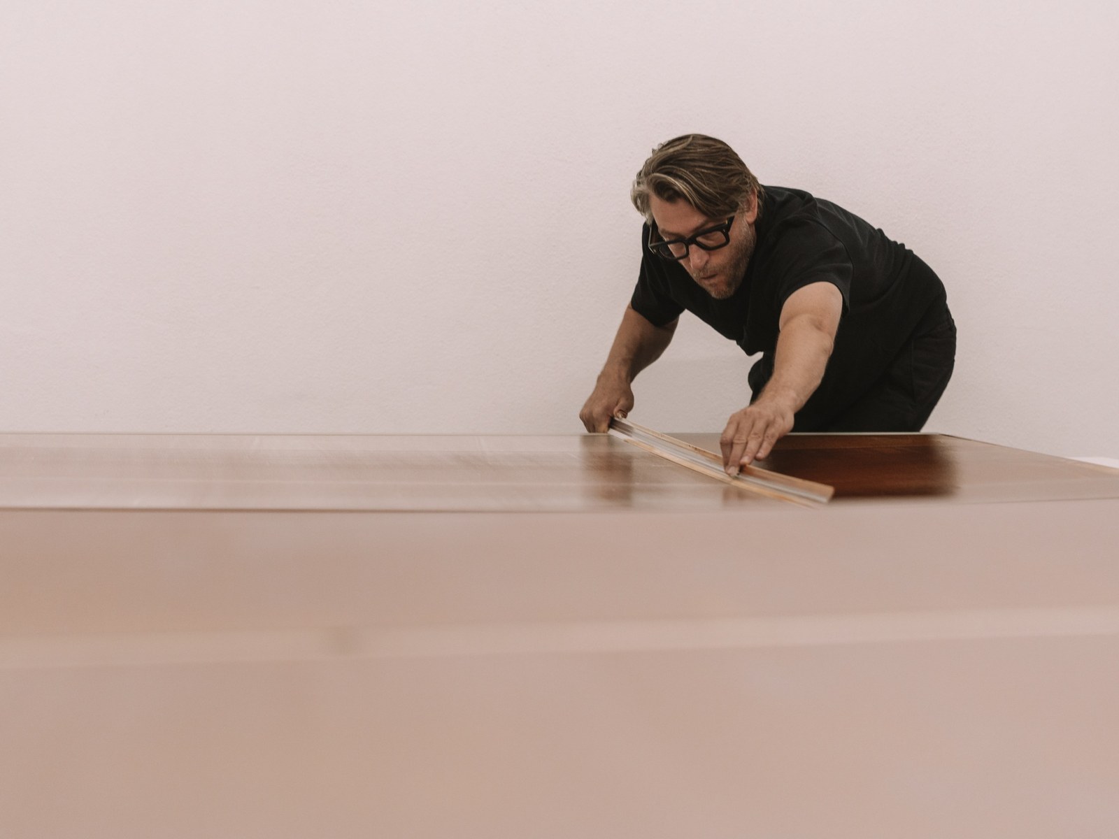 Alex Kuznetsov working on a painting with an aluminium straightedge in the studio